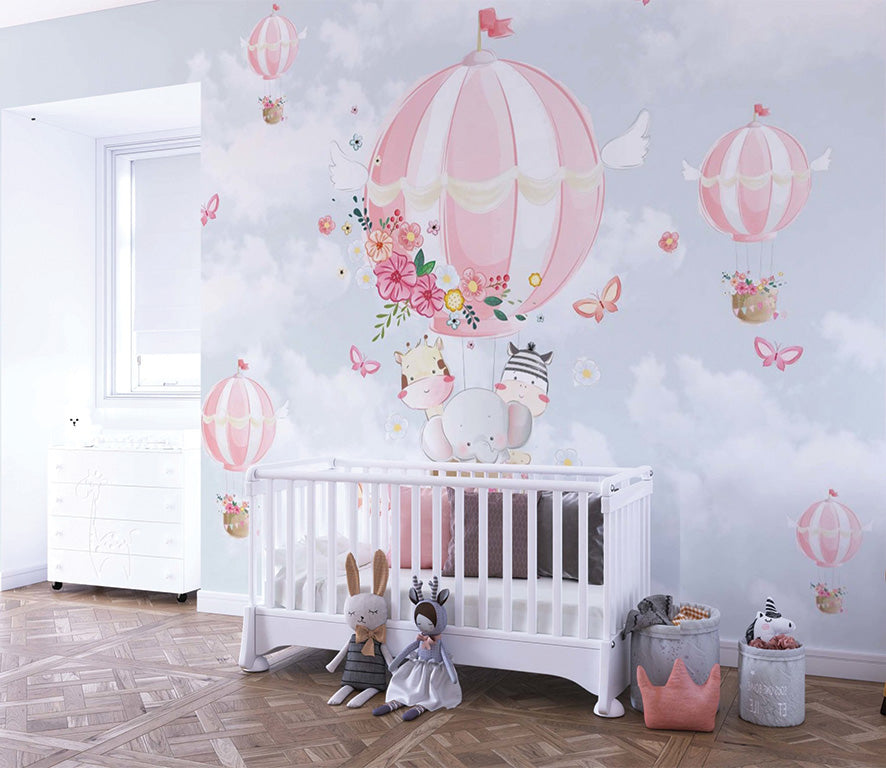 This adorable illustration shows pink hot air balloons adorned with flowers and bunting, floating through a cloudy sky surrounded by butterflies. Inside the main balloon, a cheerful trio of animals—an elephant, a giraffe, and a zebra—peek out playfully. A whimsical and heartwarming scene perfect for children's decor or nursery themes.