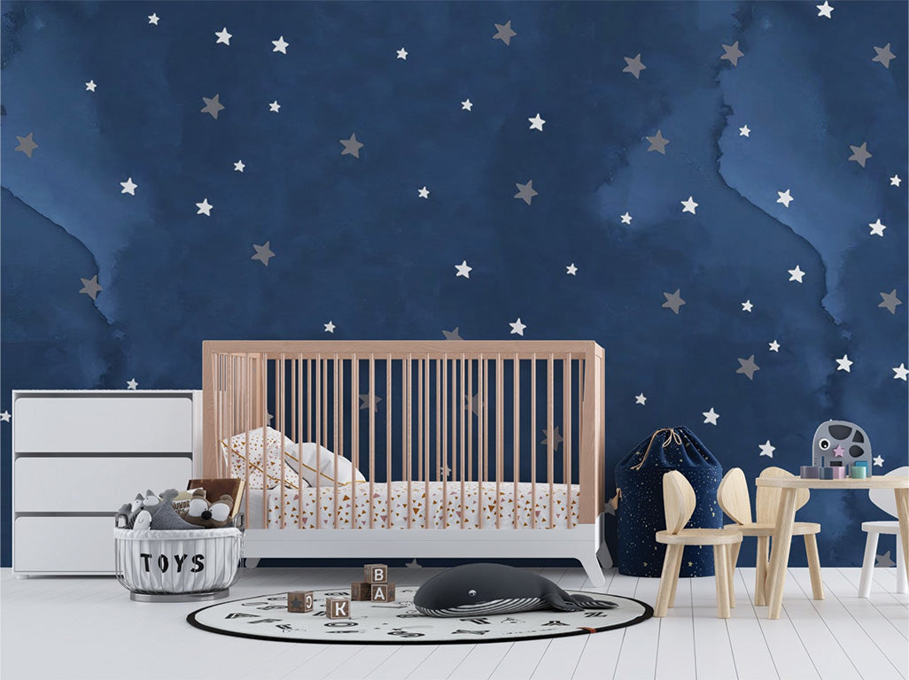 A deep blue background with a watercolor effect, adorned with scattered stars in shades of white and gray. The stars vary in size, creating a dreamy, celestial atmosphere reminiscent of a peaceful night sky. The soft tones and abstract design add a whimsical and calming feel.