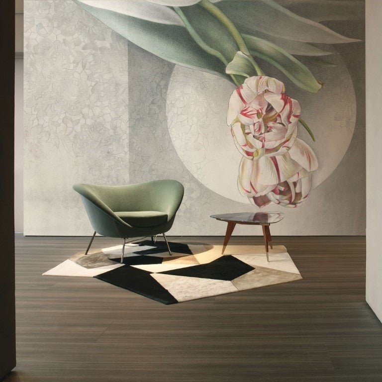 Abraccio - Custom Wallpaper Mural l Wallab Egypt. A modern interior space featuring a large wall mural with an intricate floral design. The room includes a stylish green chair, a small wooden table, and a geometric-patterned rug, creating a sophisticated and artistic ambiance.