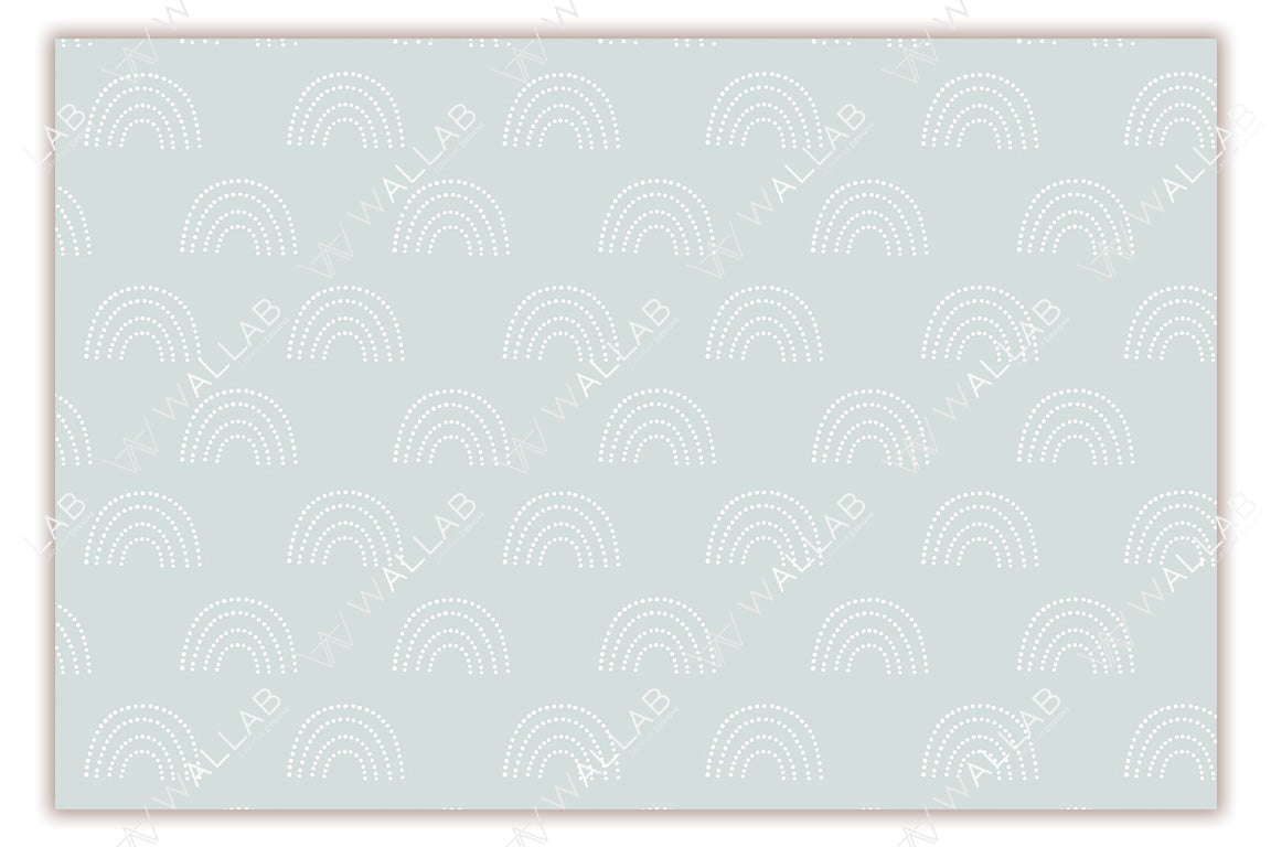 A soft blush-colored background adorned with a repeating pattern of white, dotted rainbows. The delicate pastel tones and minimalistic design create a calm and playful aesthetic, ideal for nurseries or children's rooms. The symmetrical layout adds to the overall soothing appeal.