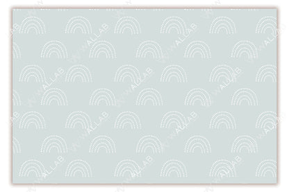 A soft blush-colored background adorned with a repeating pattern of white, dotted rainbows. The delicate pastel tones and minimalistic design create a calm and playful aesthetic, ideal for nurseries or children's rooms. The symmetrical layout adds to the overall soothing appeal.