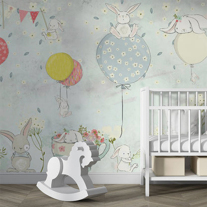 This whimsical illustration features adorable bunnies in a playful scene with colorful balloons and a floral tea cup. The soft pastel colors, including blues, pinks, and yellows, create a calming and cheerful atmosphere. Perfect for nursery decor or children's spaces, this design radiates charm and innocence.