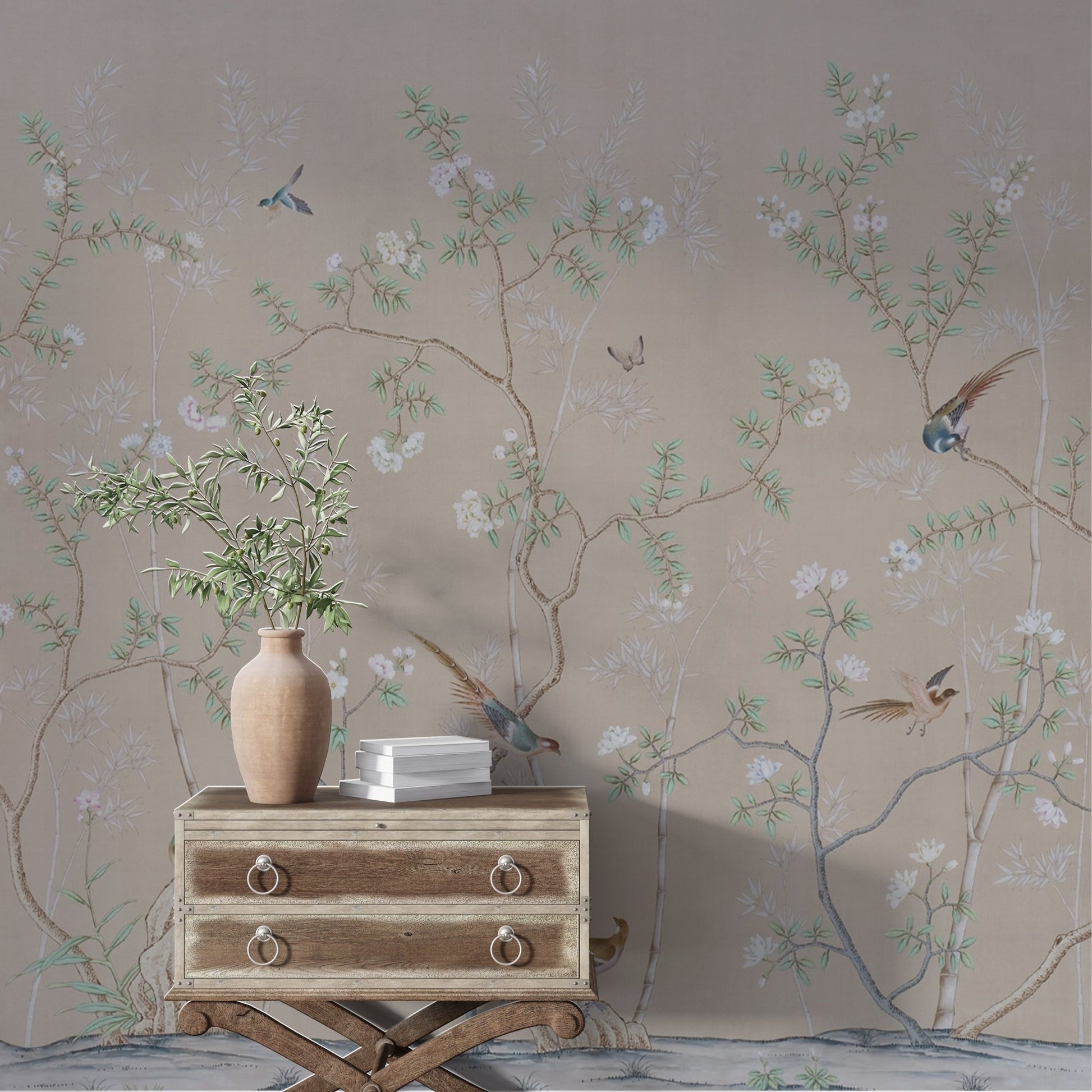 A delicate wallpaper design featuring intricate branches with light green leaves and blooming white flowers against a muted beige background. Small birds, in various poses, perch gracefully on the branches or fly mid-air, adding life to the serene and elegant scene. The composition has a soft, traditional, and nature-inspired aesthetic.